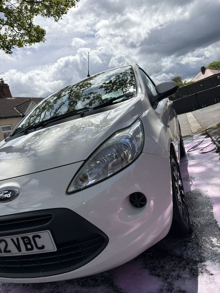 White Ford Ka front-on with snow foam on driveway